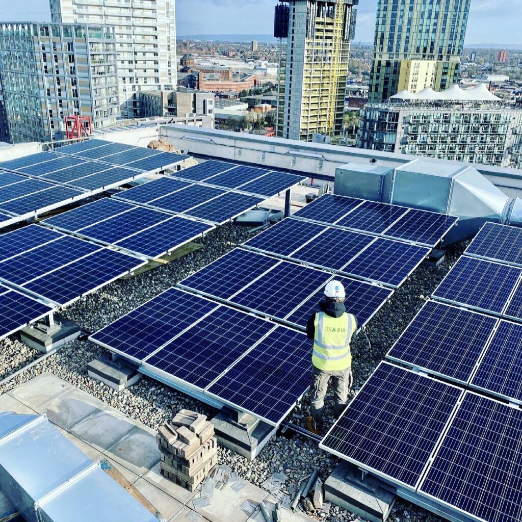 Technician inspecting rooftop commercial solar panels in the city.