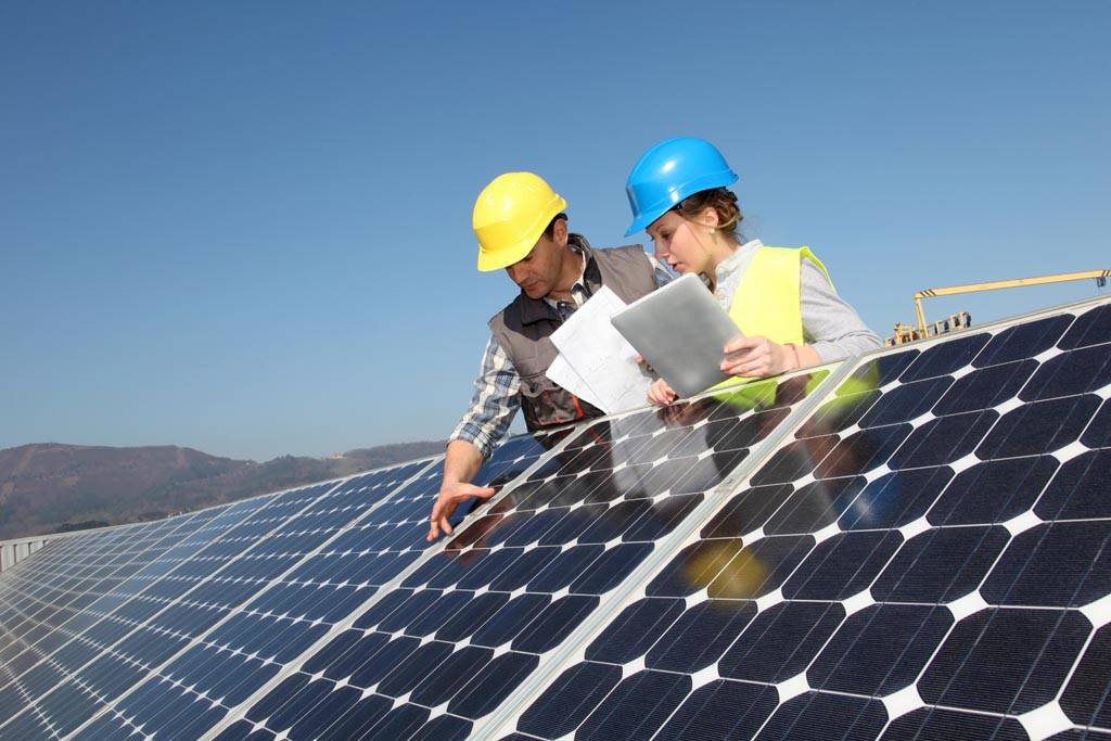 Engineers inspecting rooftop solar panels.